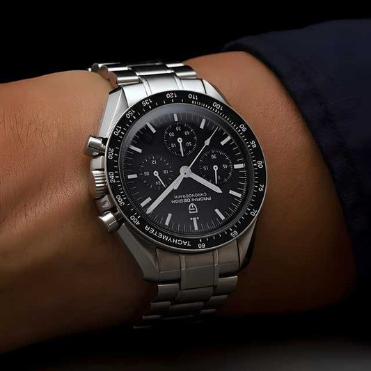 Silver watch with a black face on a wrist against a dark background
